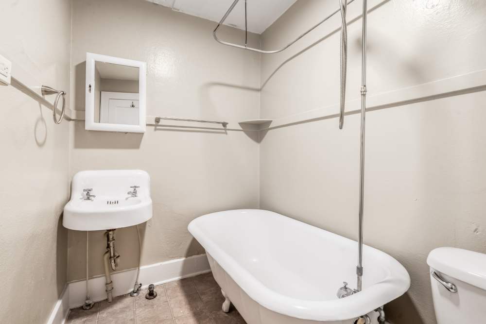 bathroom with pedestal sink, mirror cabinet, and clawfoot tub at Cascade Park in Colorado Springs, Colorado