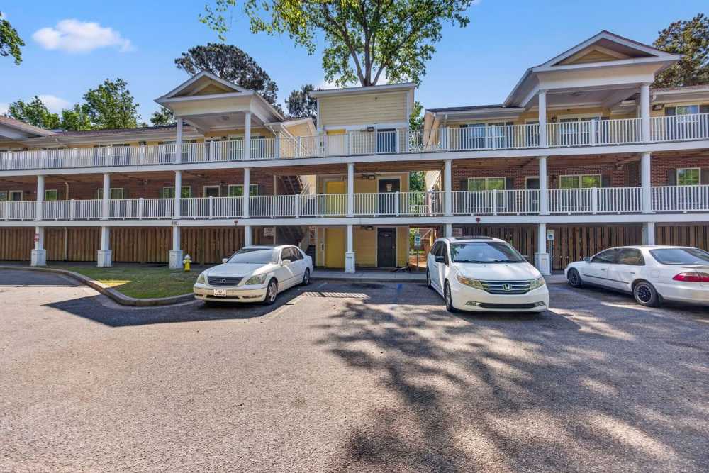 Exterior view of apartment building with parking at Pinecrest Greene in Charleston, South Carolina