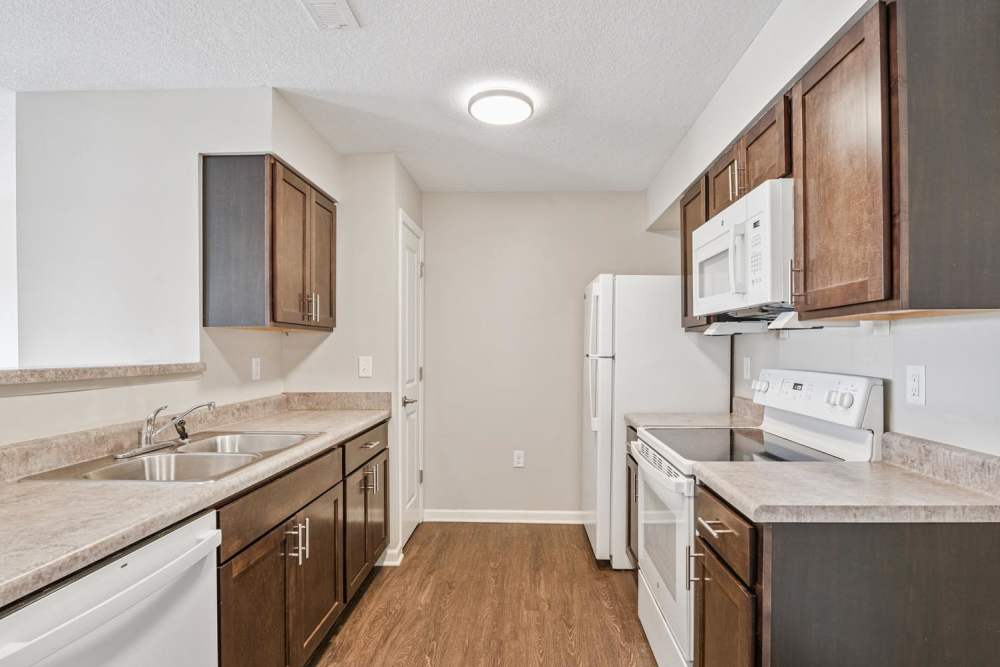 Modern kitchen with wood-style flooring at Johnston Crossing II in Johnston, Iowa