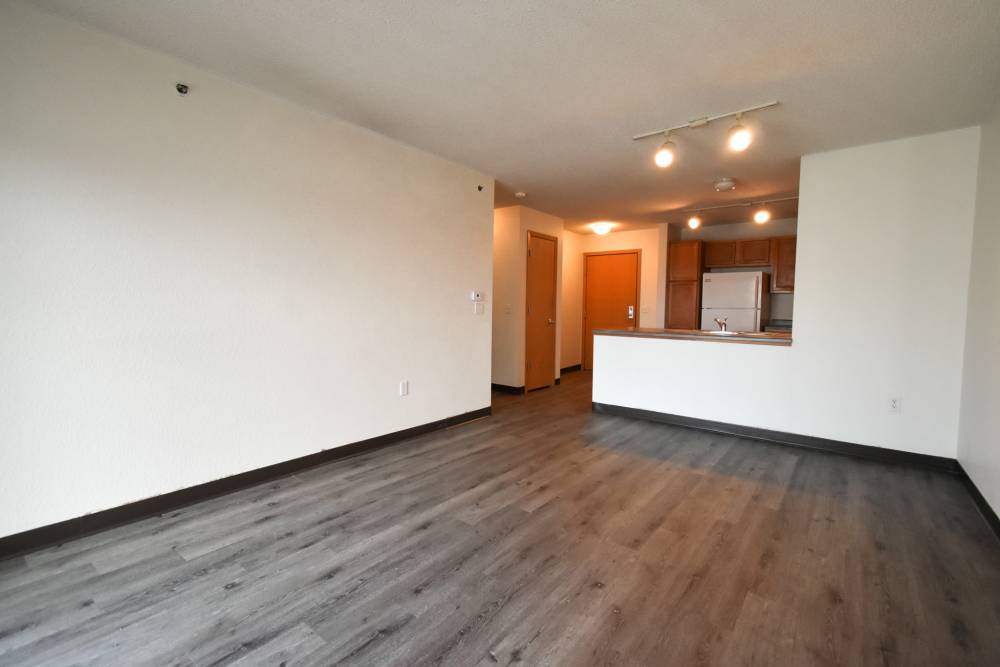 Open layout with wood-style flooring and kitchen island at River Run Apartments in Minneapolis, Minnesota