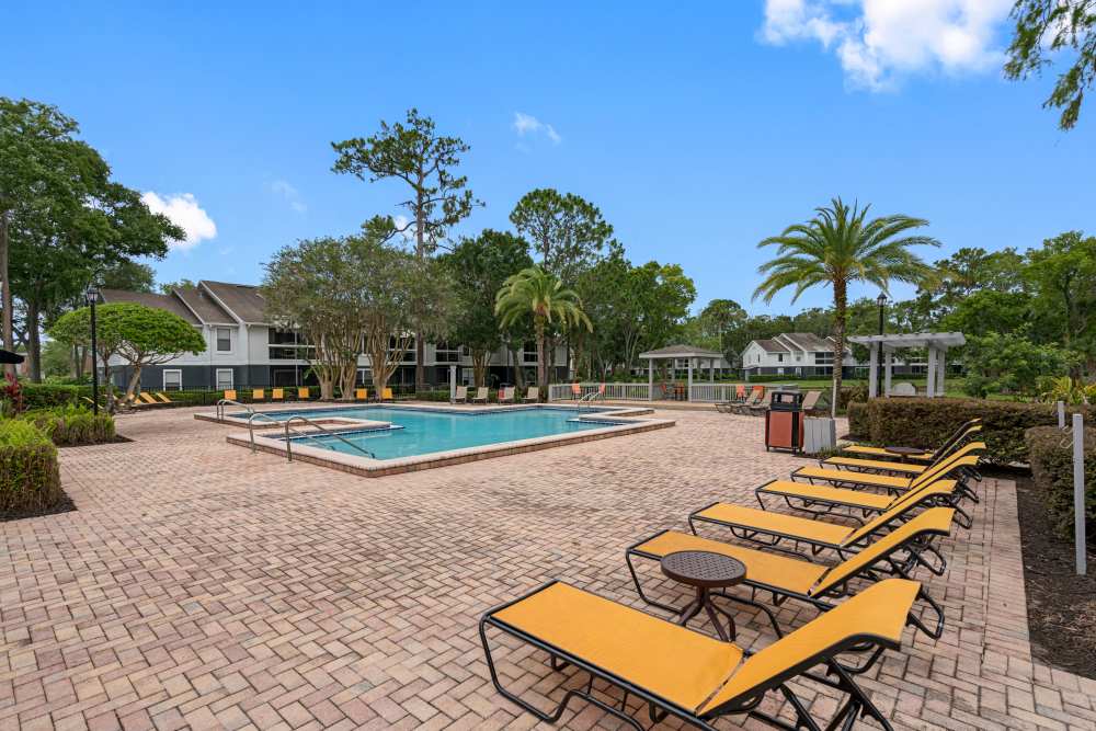 Resort-style pool area with lounge chairs at Lake Forest in Daytona Beach, Florida