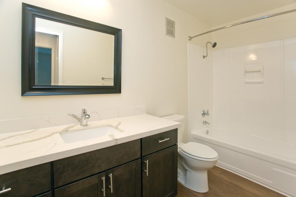 Modern bathroom with vanity, mirror and tub shower at Beach Cove in Foster City, California