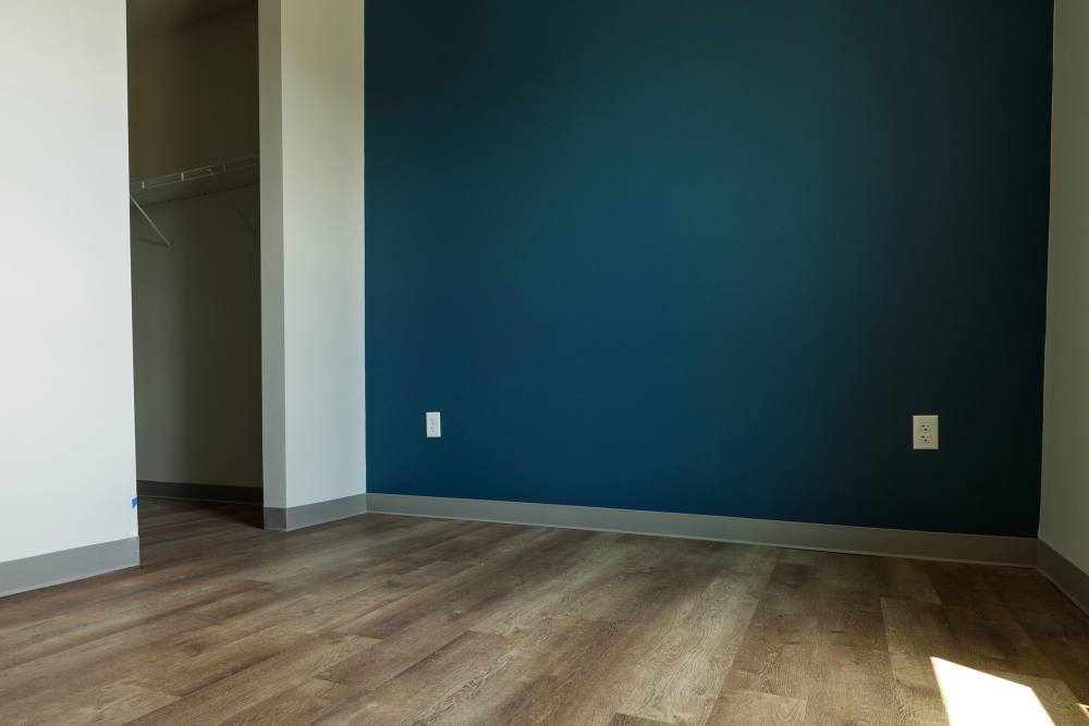 Bedroom with teal wall, closet nook, and wood flooring at Monarch Station in Louisville, Kentucky