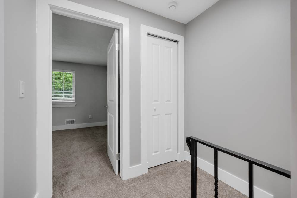 Bright hallway with carpeted flooring at Valley Brook Townhomes in Rochester, New York