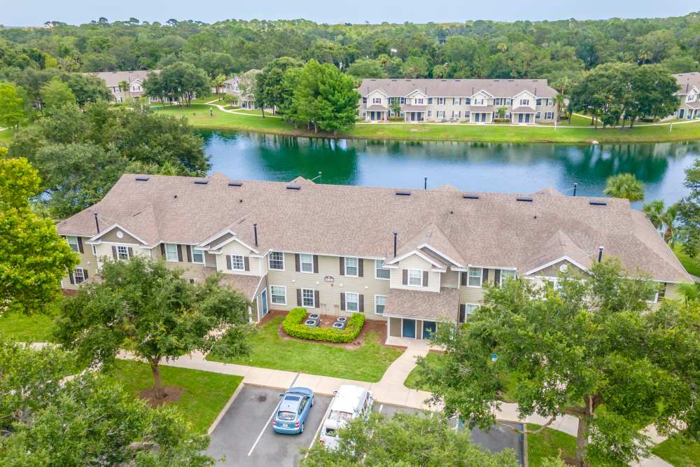 Aerial view of apartment buildings near water near Newport Sound Apartments in New Smyrna Beach, Florida