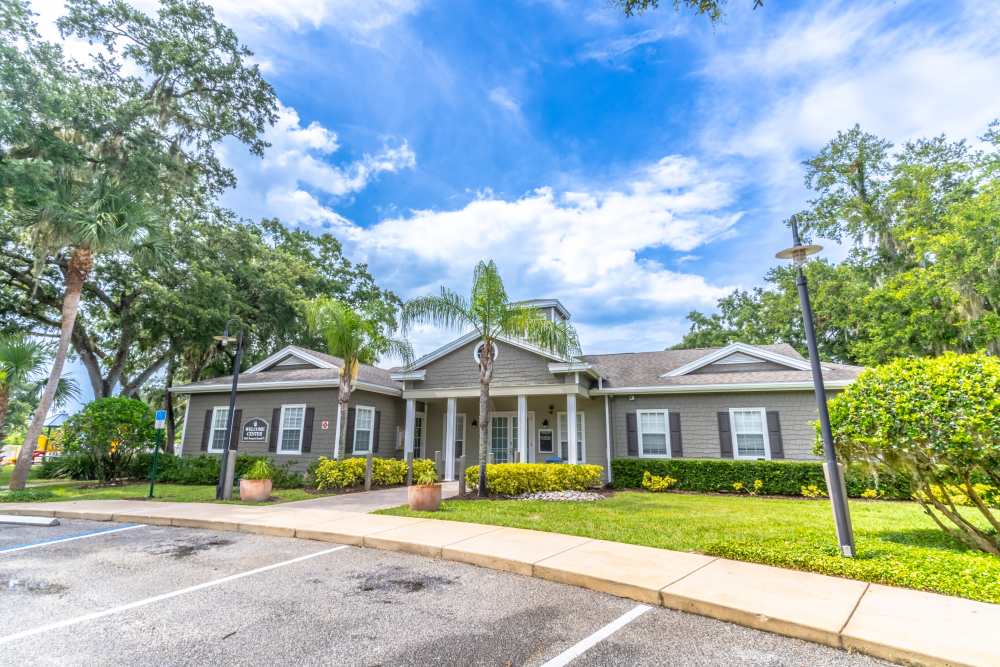 Bright clubhouse with landscaped entrance at Newport Sound Apartments in New Smyrna Beach, Florida
