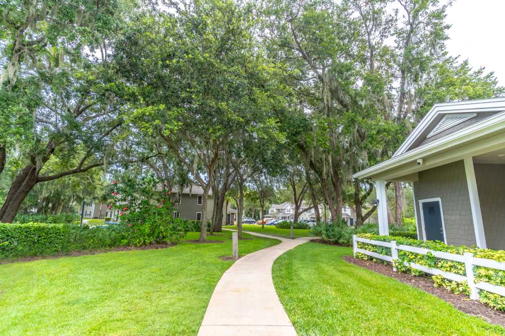 Lush pathway winding through landscaped grounds near Newport Sound Apartments in New Smyrna Beach, Florida