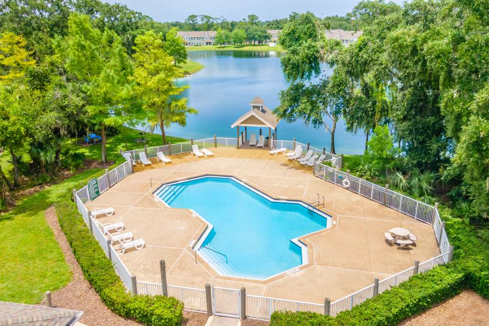Resort-style pool with seating area at Newport Sound Apartments in New Smyrna Beach, Florida