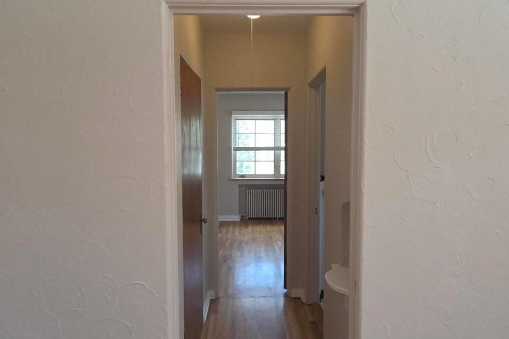 Hallway with white walls, wood flooring, and doorways leading to rooms at Cascade Park in Colorado Springs, Colorado