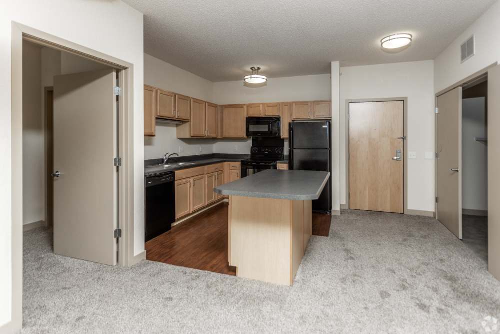 Open layout kitchen with granite countertops and island at Metro Lofts in Des Moines, Iowa