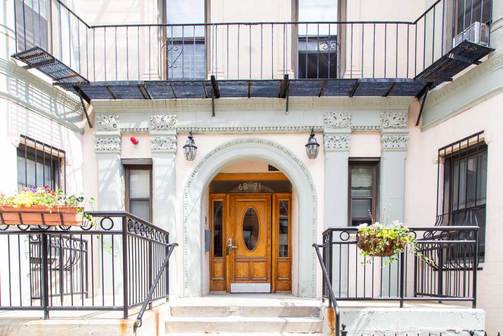 Front entrance with double wooden doors, archway and decorative facade at 71 Westland Apartments in Boston, Massachusetts