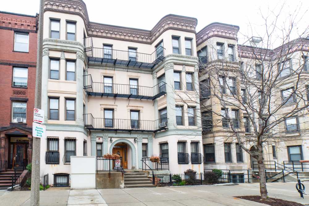 Exterior view of the building with classic facade, balconies, and arched doorway at 71 Westland Apartments in Boston, Massachusetts