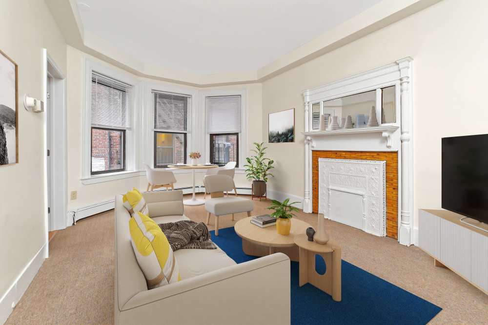 Bright living room with fireplace, sofa, coffee table, and bay windows at 71 Westland Apartments in Boston, Massachusetts