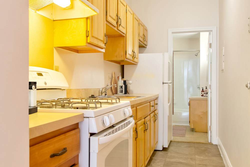 Kitchen with wooden cabinets and white appliances at 71 Westland Apartments in Boston, Massachusetts