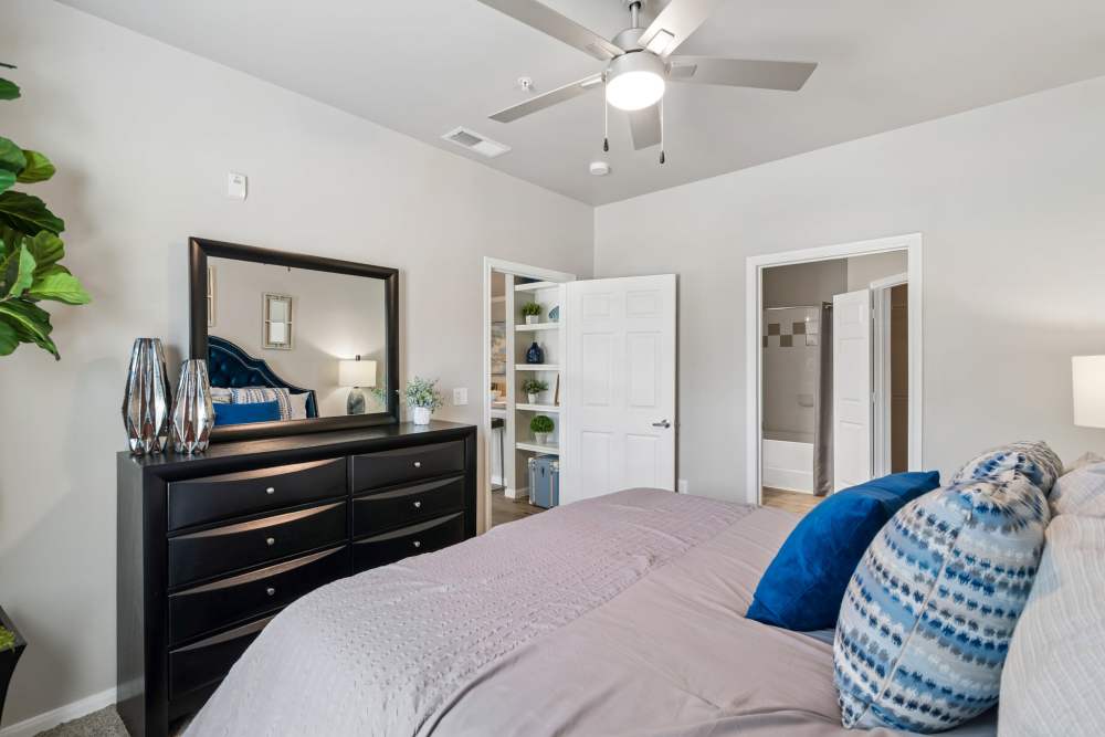 Cozy bedroom featuring a stylish bed, decorative pillows, and modern bedside lamps at Residence at Lake Jackson in Lake Jackson, Texas