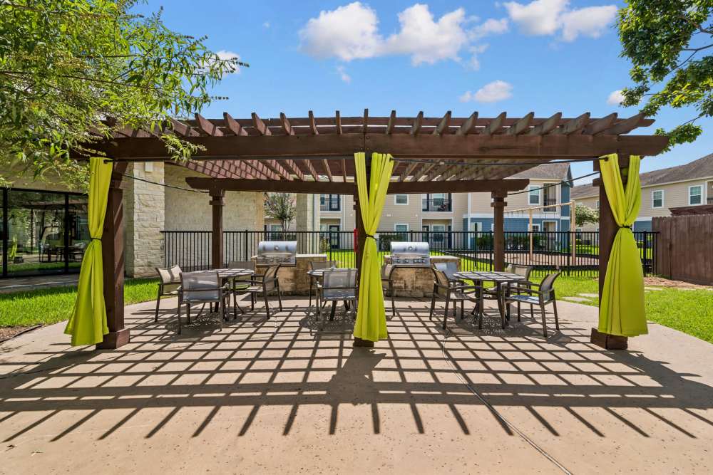 Cozy outdoor cabana with dining tables and a BBQ grill at Residence at Lake Jackson in Lake Jackson, Texas