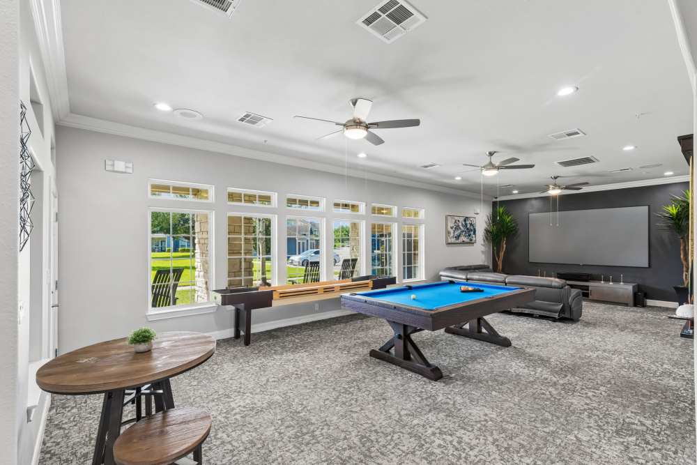 Game room featuring a pool table, comfortable seating, and large windows for natural light at Residence at Lake Jackson in Lake Jackson, Texas