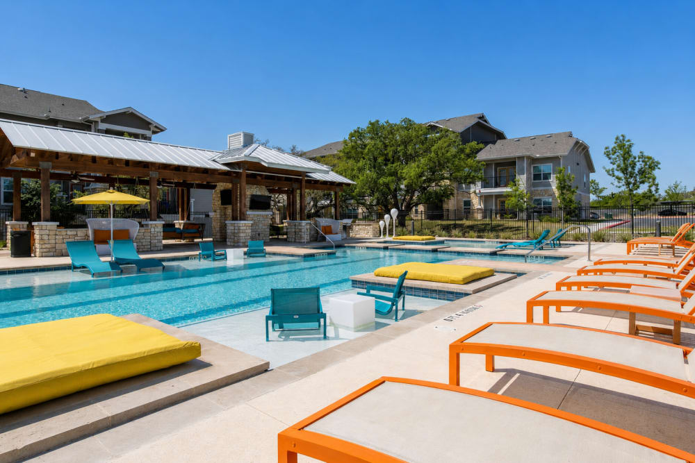 Lounge chairs by the sparkling swimming pool at Esperanza in San Antonio, Texas