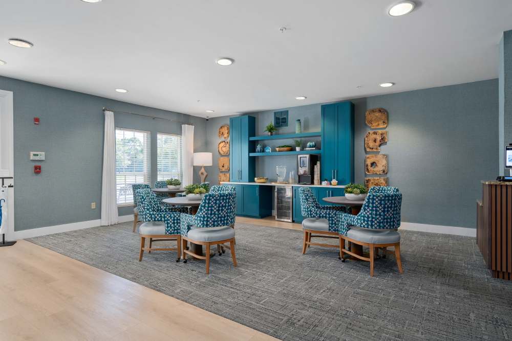 Bright community lounge with dining tables and comfortable seating at Gentry Park Orlando in Orlando, Florida