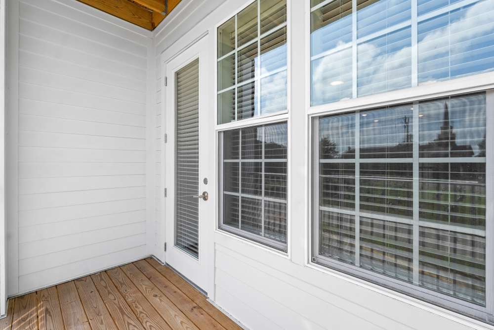 Bright bedroom with large windows and wood-style flooring at The Cascade at Foundry Creek in Richmond, Virginia
