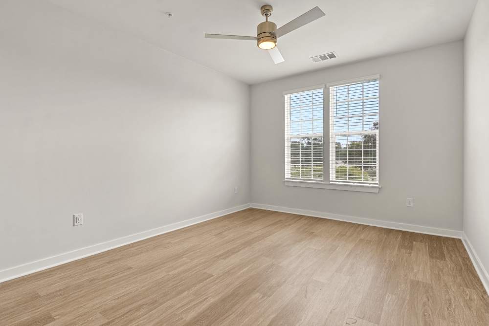 Bedroom with ceiling fan, neutral walls, and large window at The Cascade at Foundry Creek in Richmond, Virginia