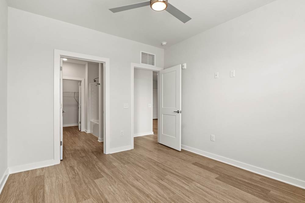 Bedroom with ceiling fan, wood-style flooring, and closet access at The Cascade at Foundry Creek in Richmond, Virginia