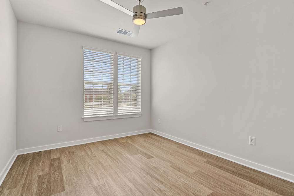 Empty bedroom with window and wood-style flooring at The Cascade at Foundry Creek in Richmond, Virginia
