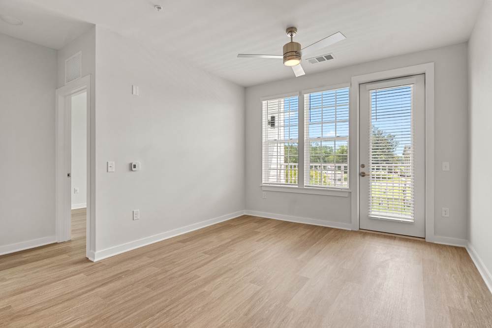Living room with patio access and oversized windows at The Cascade at Foundry Creek in Richmond, Virginia