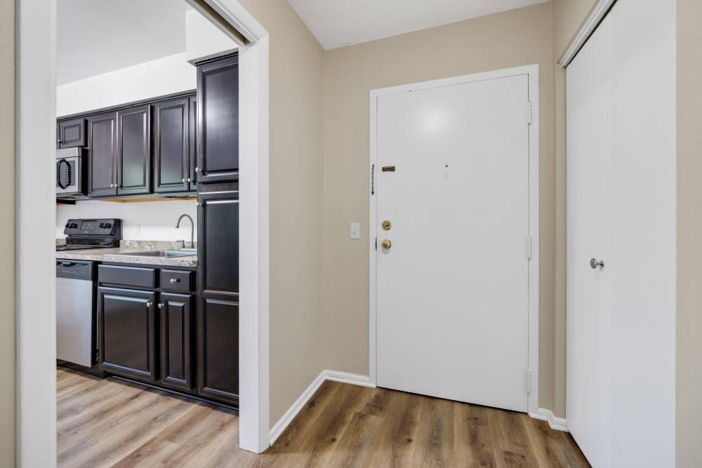 Entryway with wood-style flooring and kitchen view at Pittsford Village Estates in Pittsford, New York