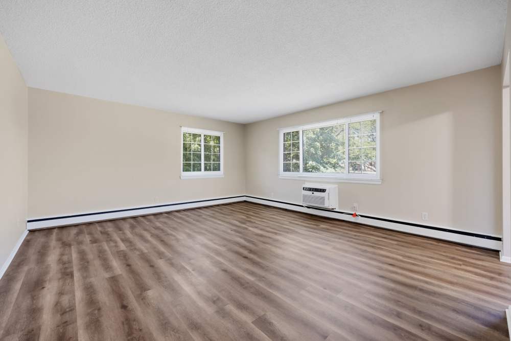 Spacious living room with large windows and modern flooring at Pittsford Village Estates in Pittsford, New York