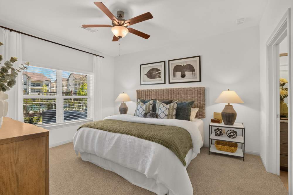Bedroom with wall of windows and ceiling fan at Fidelis Willis. 