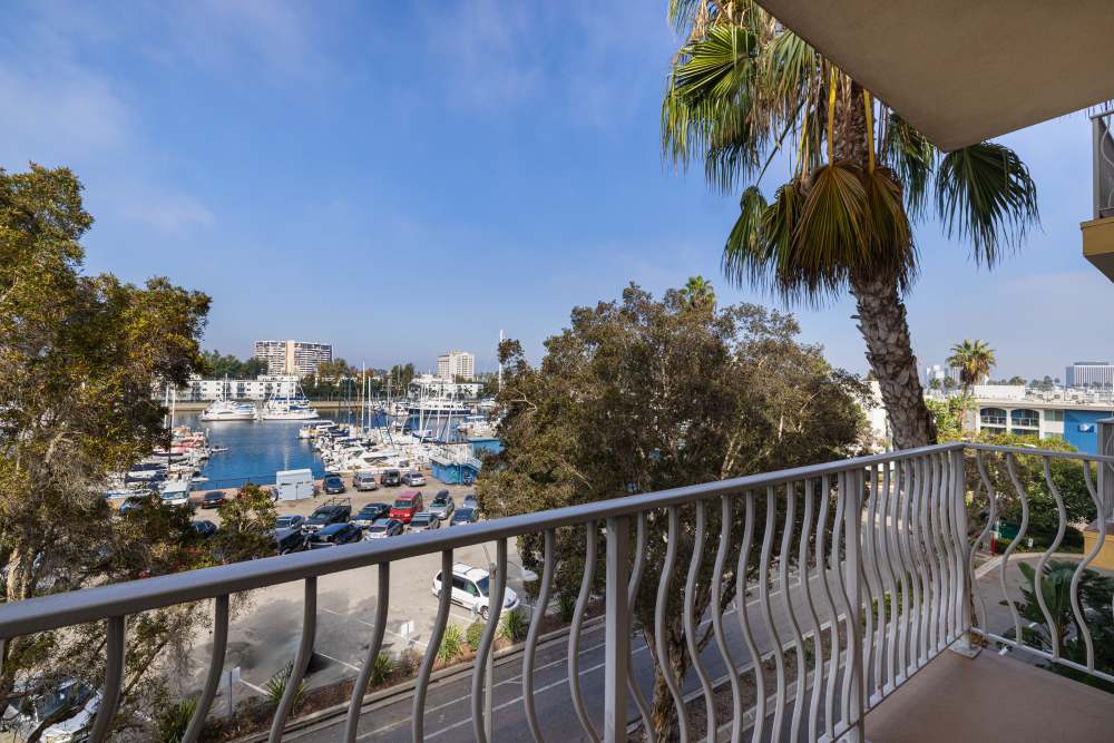 Balcony view of marina and palm trees near St Tropez Apartments in Marina Del Rey, California