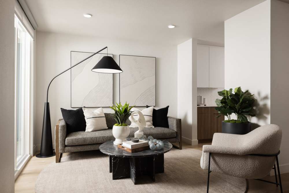 A furnished living room with a couch, potted plants and a coffee table at Dolphin Marina Apartments in Marina Del Rey, California