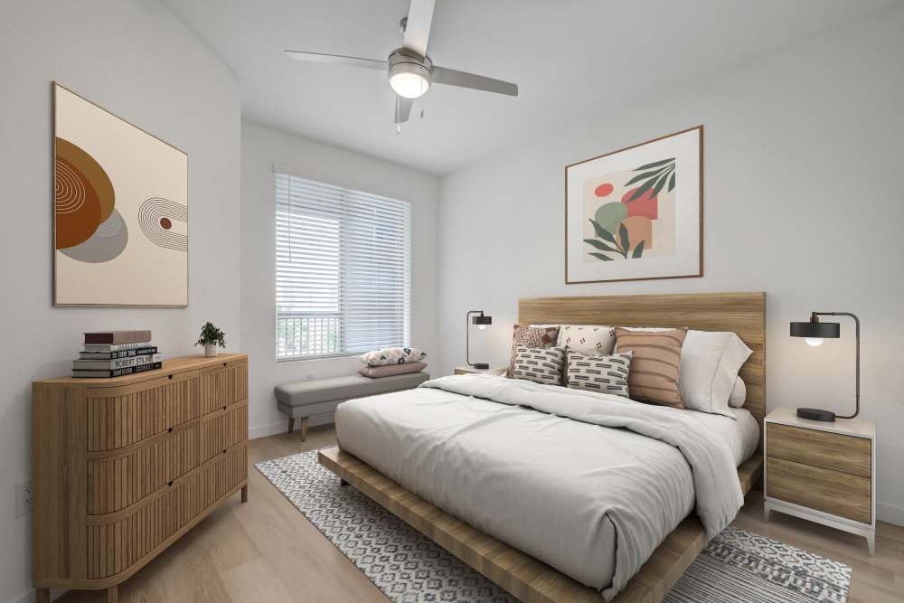 Modern bedroom with wood furniture, neutral décor, and natural light at Heirloom at Bruner in Las Vegas, Nevada