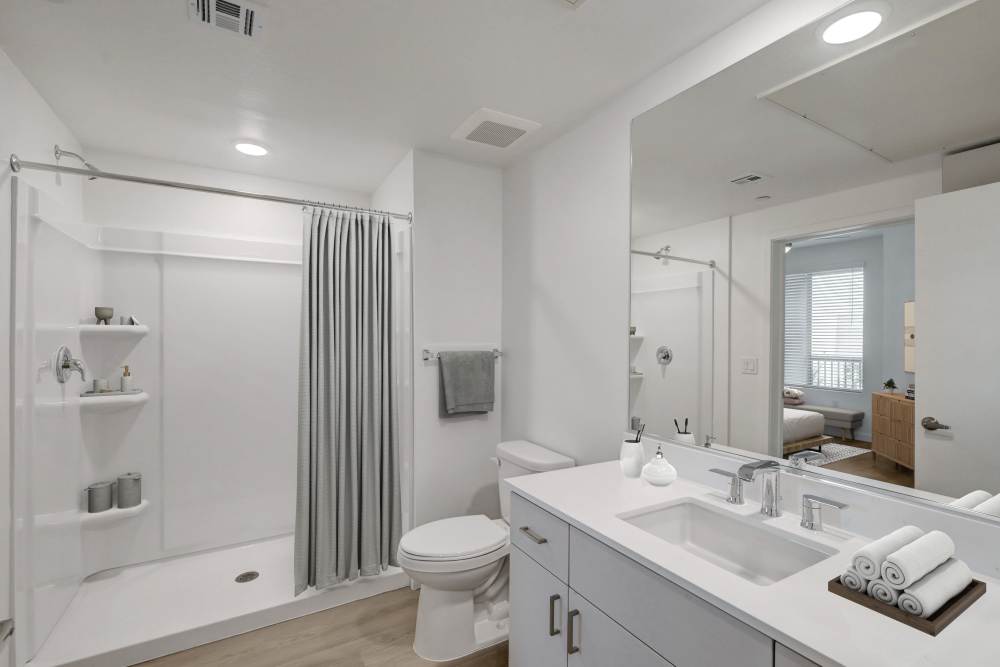 Clean bathroom with white vanity, shower, and bright lighting at Heirloom at Bruner in Las Vegas, Nevada
