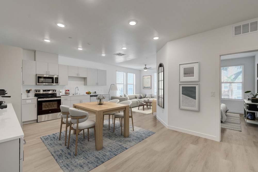 Open kitchen and dining area with light cabinetry and wood flooring at Heirloom at Bruner in Las Vegas, Nevada