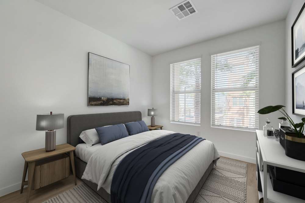 Bright bedroom with modern bed, wood nightstands, and large windows at Heirloom at Bruner in Las Vegas, Nevada