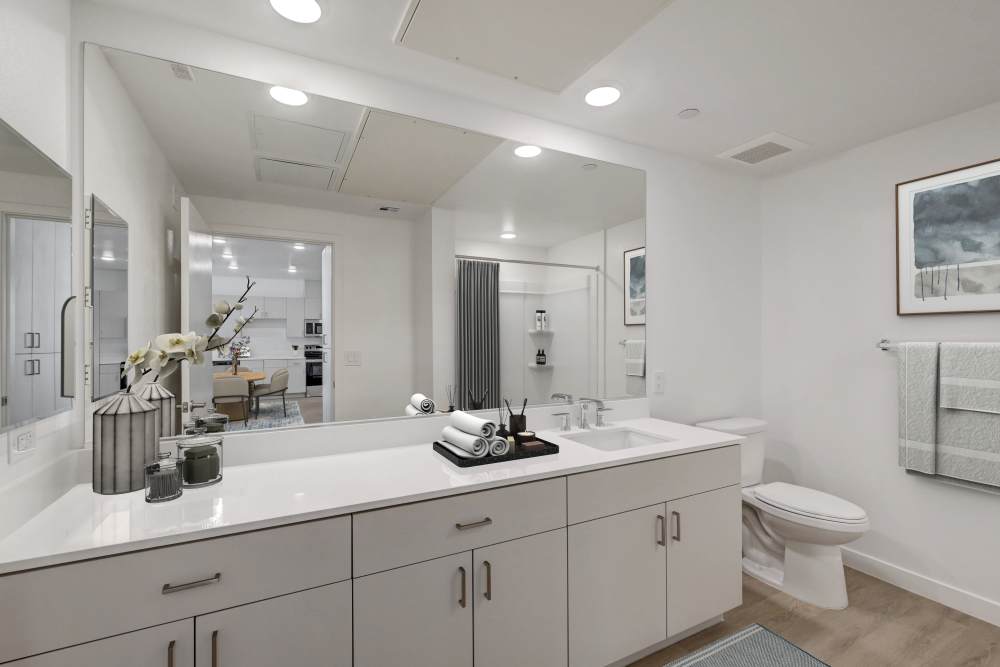 Spacious bathroom with wide vanity, large mirror, and modern fixtures at Heirloom at Bruner in Las Vegas, Nevada