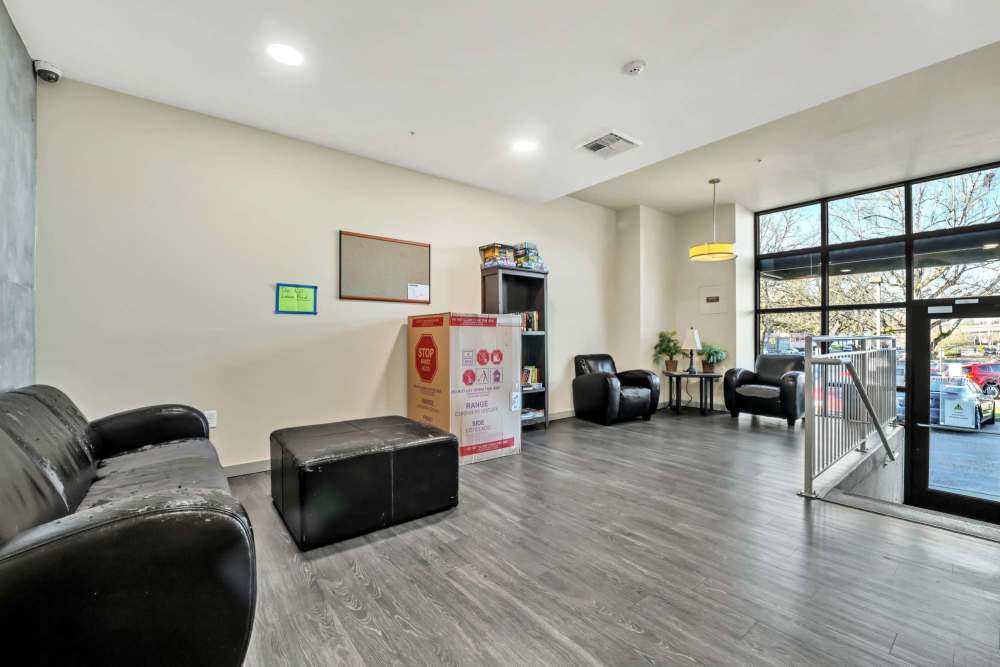 Resident lounge featuring comfortable seating, modern décor, and floor-to-ceiling windows at North Main Village in Milwaukie, Oregon  