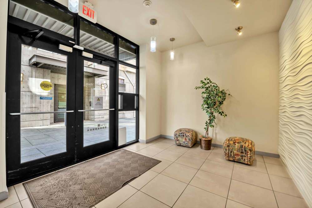 Spacious apartment entryway with large glass doors, modern flooring, and contemporary finishes at North Main Village in Milwaukie, Oregon  
