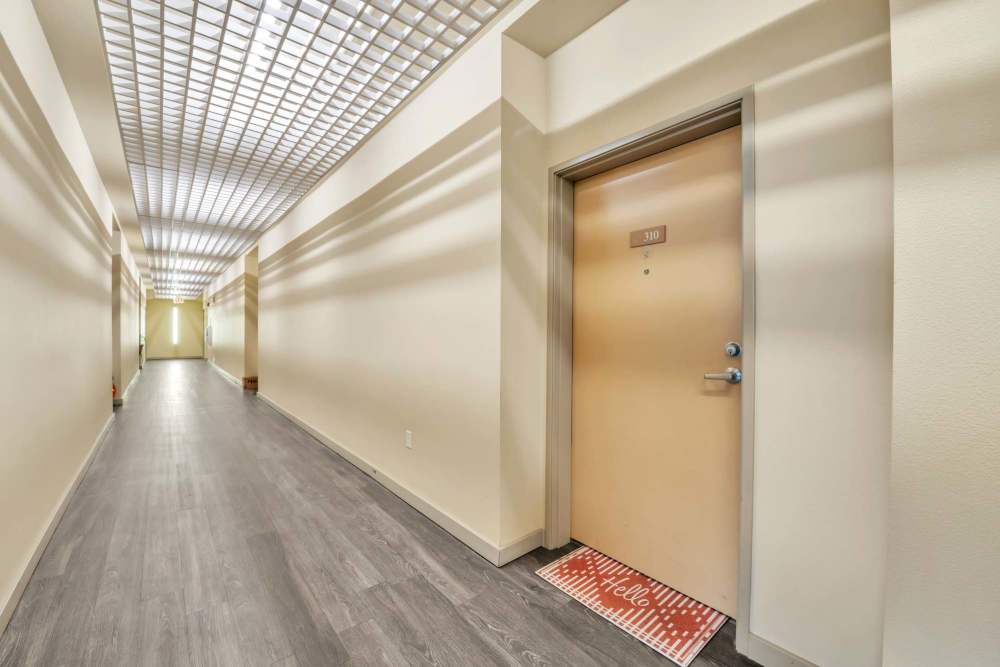 Contemporary interior corridor featuring decorative ceiling details, wood-finish doors, and soft lighting at North Main Village in Milwaukie, Oregon  