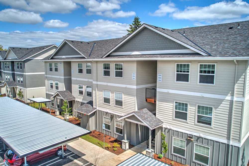 Exterior view of modern apartment buildings with covered parking, Cleveland Crossings in Woodburn, Oregon