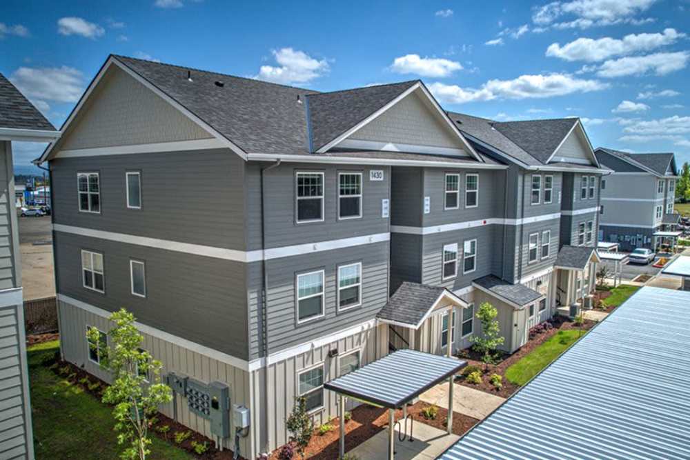 Corner view of apartment community with covered walkways and landscaping, Cleveland Crossings in Woodburn, Oregon