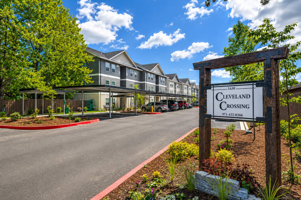 Apartment community entrance with monument sign and landscaped driveway, Cleveland Crossings in Woodburn, Oregon