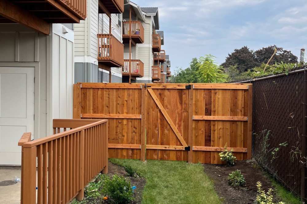 Ground-floor apartment patio with fenced yard at Cleveland Crossings in Woodburn, Oregon