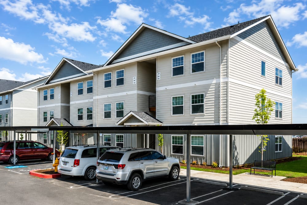 Apartment building exterior with covered parking and landscaped grounds, Cleveland Crossings in Woodburn, Oregon