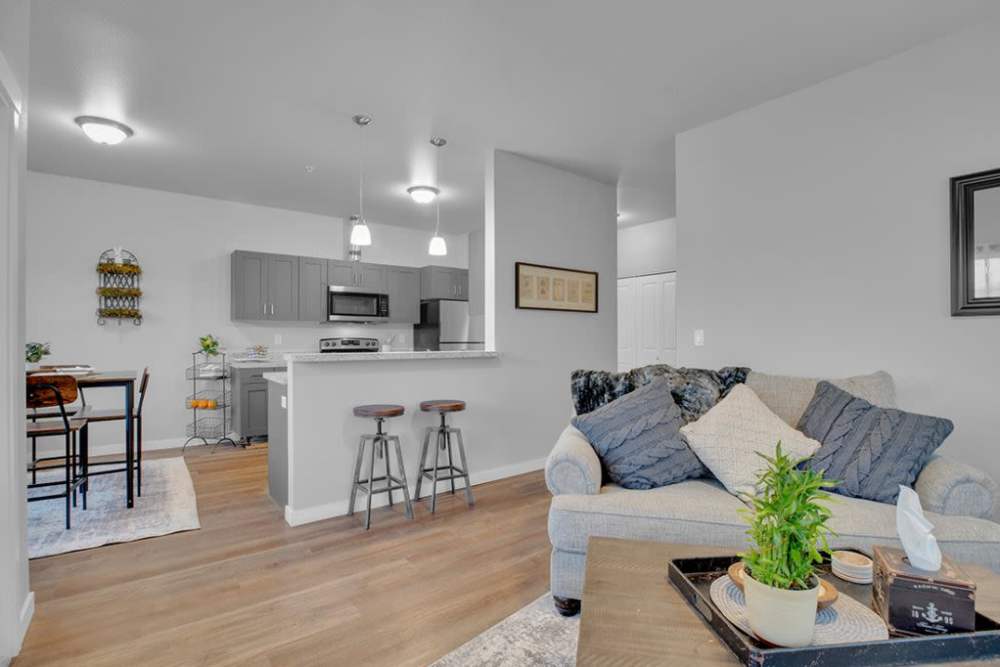 Bright living room and kitchen with breakfast bar in open floor plan, at Cleveland Crossings in Woodburn, Oregon