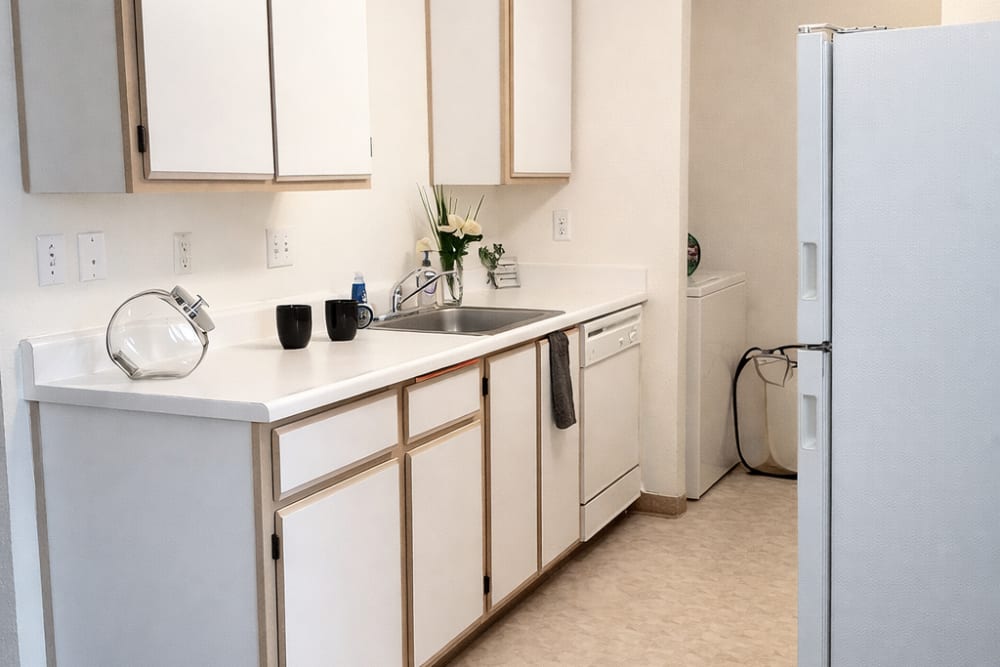Modern galley kitchen with white cabinetry, stainless steel appliances, and ample counter space at Reedville Meadows in Beaverton, Oregon  