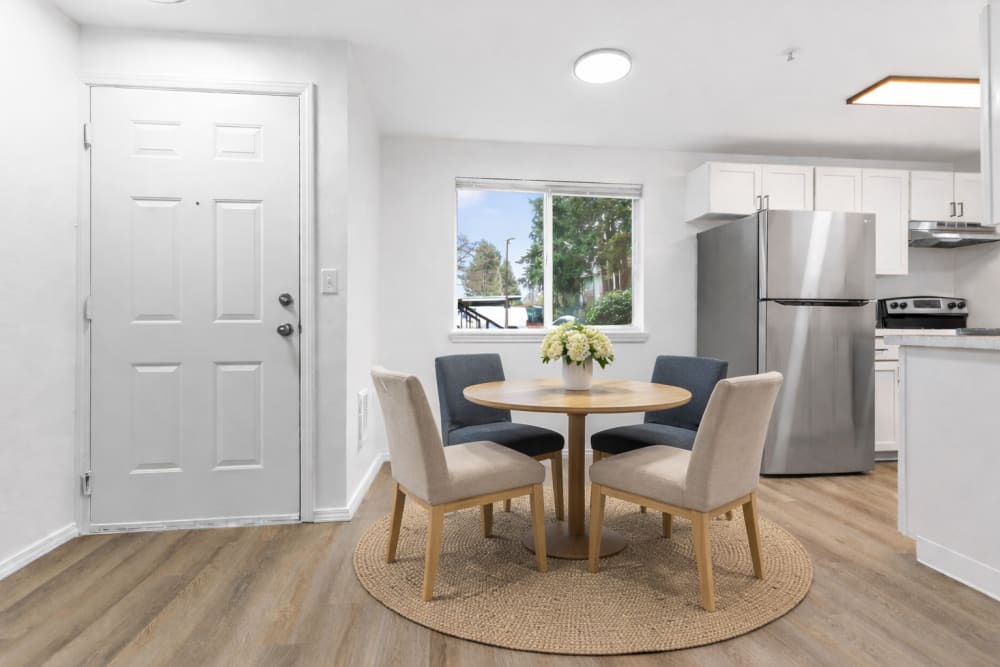 Bright apartment entryway with white front door, modern flooring, and open-concept living space at Reedville Meadows in Beaverton, Oregon  