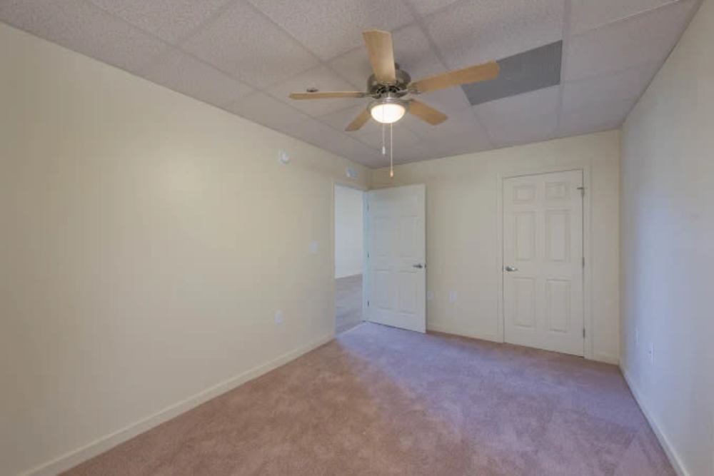 Carpeted bedroom with ceiling fan at A.L. Miller Village in Macon, Georgia
